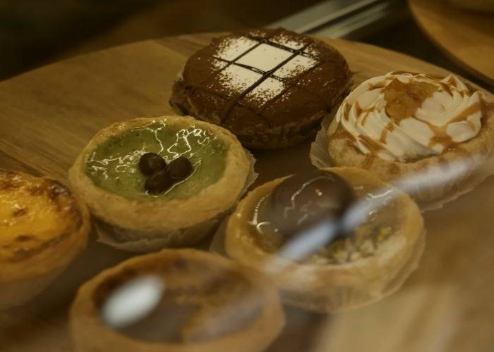 A selection of pastel de nata in different flavors, including chocolate, matcha and chestnut.